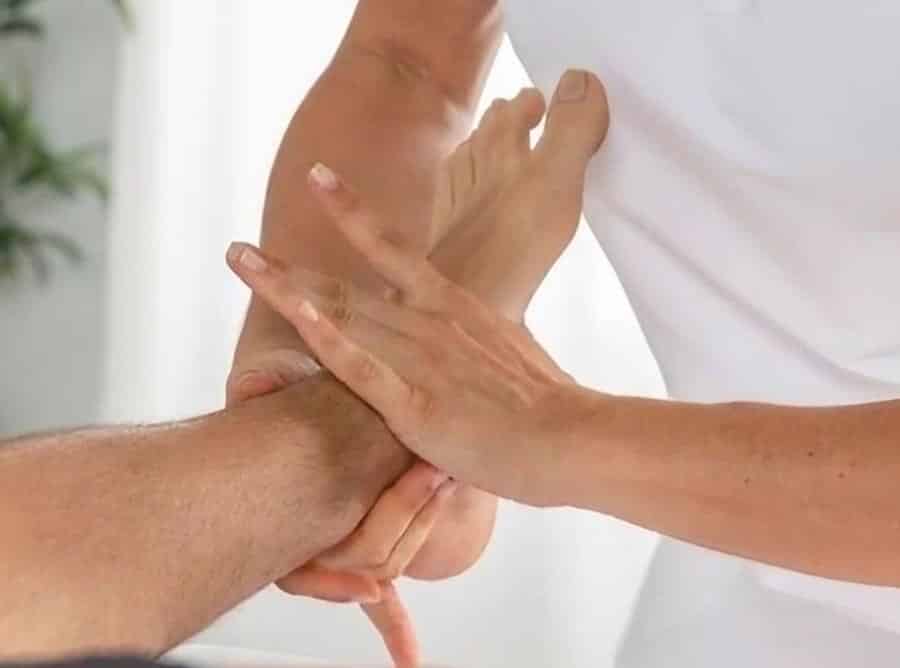 fisio sujetando el tobillo de un paciente