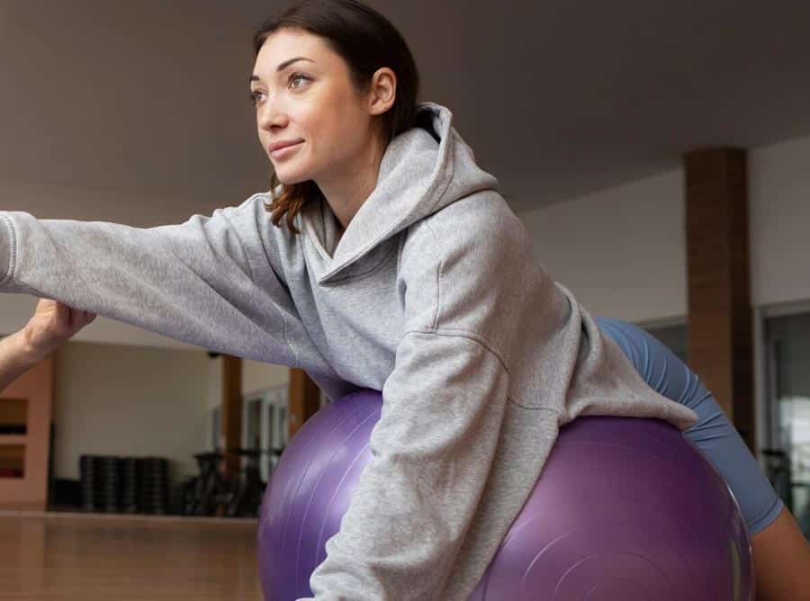 mujer sobre un balon de pilates